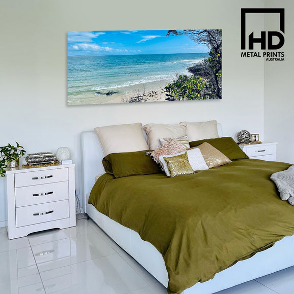 Bedroom with metal print of beach above bed